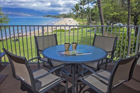Sip your morning coffee on your private balcony overlooking pristine beach, turquoise waters, swaying palms, and distant mountains—your tropical paradise awaits.