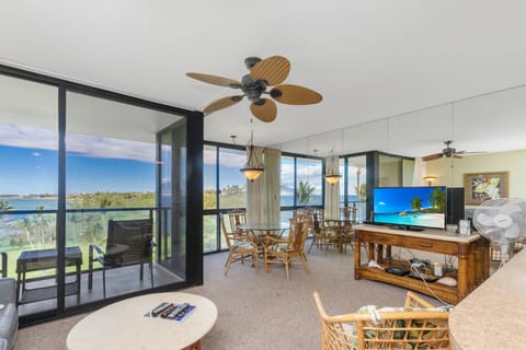 Your open living space frames expansive ocean and landscape views through floor-to-ceiling windows, with ceiling fans to keep you comfortable while you dine or unwind by the balcony.
