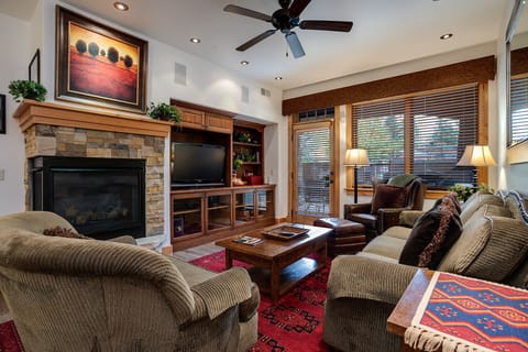 Unwind in your elegant living room with cozy fireplace, entertainment center, and plush seating—perfect for relaxing evenings together.