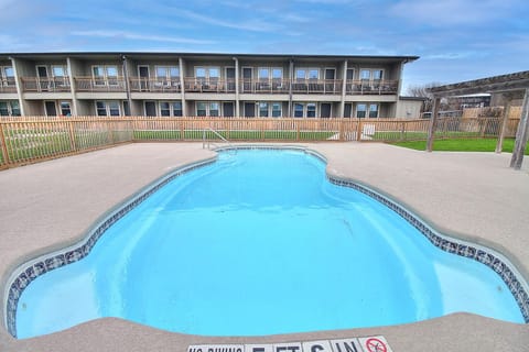 Property's sparkling blue swimming pool awaits, with sunny deck area perfect for relaxing between refreshing dips.