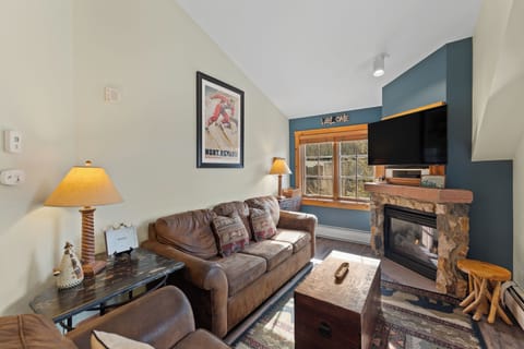 Curl up on the plush leather sofa by your crackling fireplace, where mountain charm meets modern comfort in your cozy retreat.