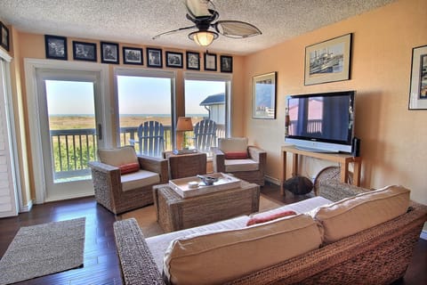 Unwind in this coastal living room where wicker furniture and warm walls create your perfect beach retreat atmosphere.