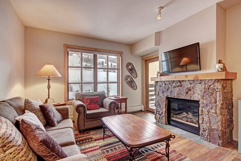 Cozy living room area with fireplace, patio, and lots of natural light.