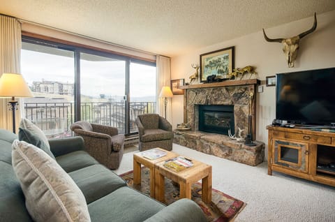 Unwind in your cozy living room with plush seating, warm fireplace, and large windows framing mountain views—your perfect retreat after adventure.