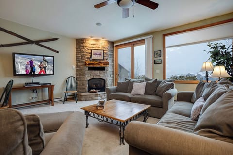 Sink into plush sofas by your cozy stone fireplace while mountain views frame your perfect evening retreat.