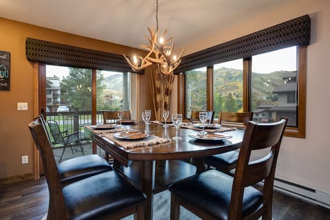 Gather around your elegant dining table where mountain views frame every meal, creating perfect moments for intimate dinners and memorable conversations.