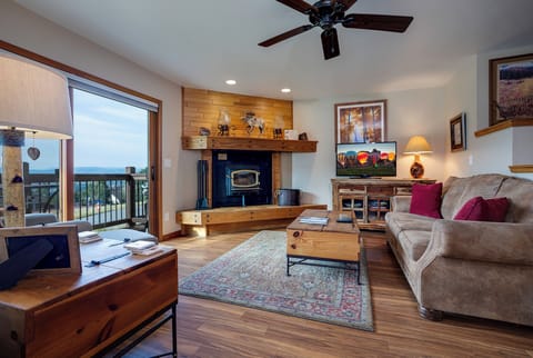 Sink into plush seating by your crackling fireplace, where warm wood accents create the perfect mountain retreat atmosphere.