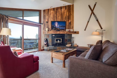 Cozy up in your mountain retreat with a crackling fireplace, plush seating, and stunning views through floor-to-ceiling windows.