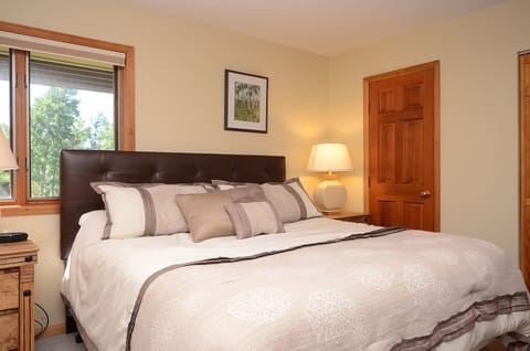 Sink into your plush king bed with soft linens while natural light streams through your window overlooking lush greenery.
