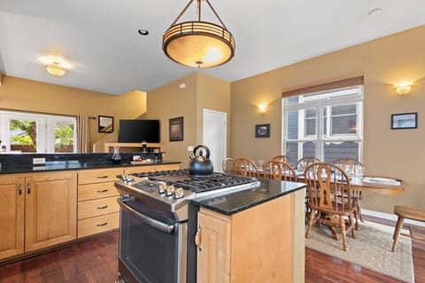 The center island has a stainless steel gas burning stove and oven combo.