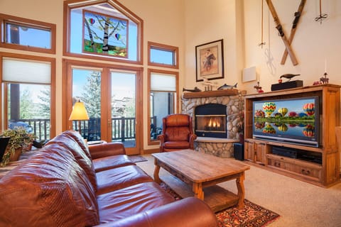 Sink into leather seating by your crackling fireplace while mountain views fill the windows in this cozy living space.