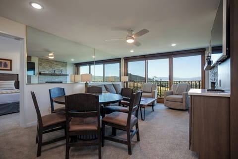 Your open-concept living space features panoramic mountain views through floor-to-ceiling windows, perfect for morning coffee or evening relaxation.