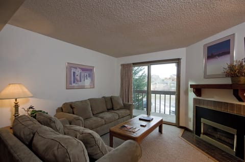 Sink into plush sofas by your private fireplace, where warm lighting and peaceful balcony views create the perfect retreat.