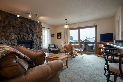 Cozy up by your stone fireplace with mountain views through your private balcony doors - perfect for relaxing after skiing.
