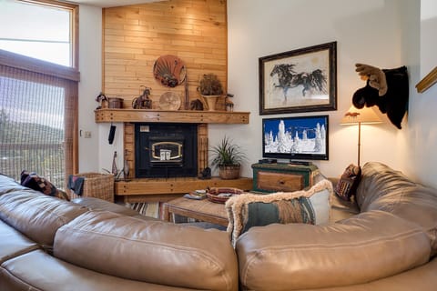 Sink into plush leather seating by your crackling fireplace, where rustic charm meets cozy comfort in your mountain retreat.