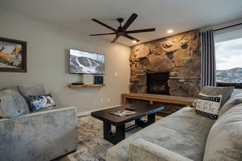 Cozy up by your stone fireplace while watching TV and enjoying mountain views through expansive windows.