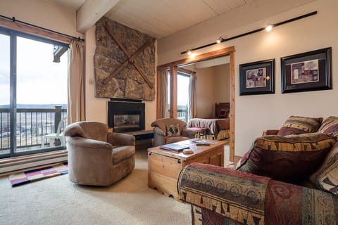 Cozy up in your mountain retreat with a crackling fireplace, plush seating, and stunning views through expansive windows.