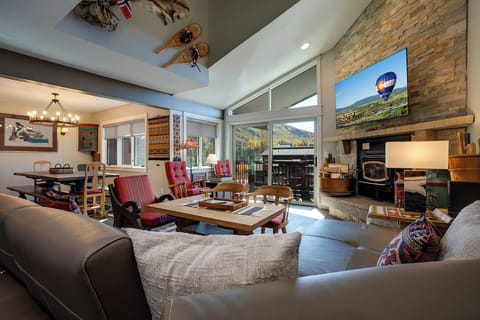Relax in this stunning mountain retreat where rustic stone fireplace meets modern comfort, offering breathtaking views through floor-to-ceiling windows.