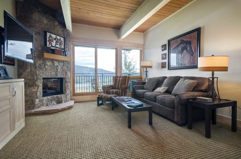 Unwind in your spacious living room with stone fireplace and mountain views from your private balcony.