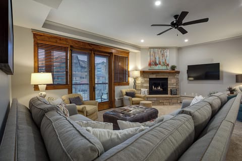 Sink into plush sectional seating while the stone fireplace warms your evening and mountain views frame your perfect retreat.