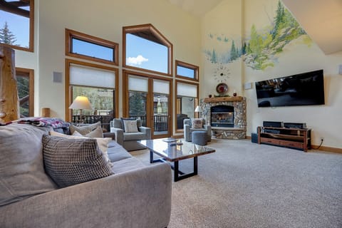 Sink into plush sofas and admire stunning mountain views through floor-to-ceiling windows. A stone fireplace and soaring ceilings create your cozy alpine retreat.