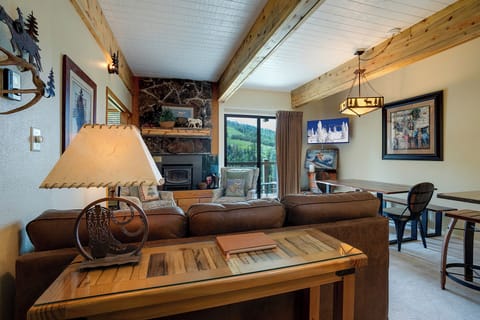 Cozy mountain retreat with exposed beams, stone fireplace, and forest views create your perfect alpine escape.