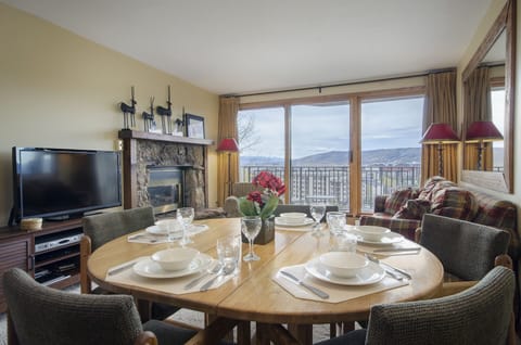 Your cozy mountain retreat features a dining table set for memorable meals and a fireplace for evening relaxation.