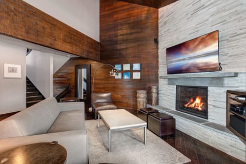 The living area with flatscreen TV, comfortable furniture, and cozy fireplace.