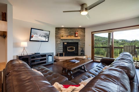 Sink into plush leather seating while your fireplace crackles and mountain views stretch beyond your private balcony.
