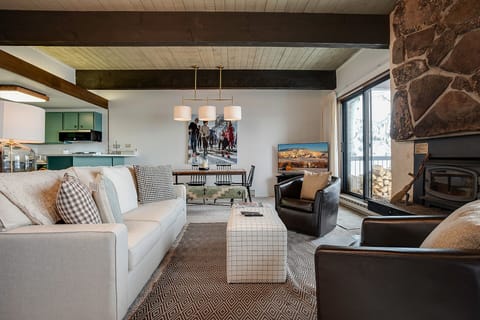 Cozy up in this beautifully appointed living space where modern comfort meets rustic charm, complete with stone fireplace and mountain views.
