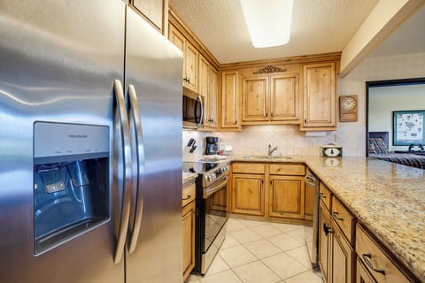 Your fully equipped kitchen features granite counters, stainless steel appliances, and warm wood cabinetry for creating memorable meals together.