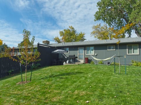 Your kitchen opens to this private fenced-in yard with seating, grill, hammock