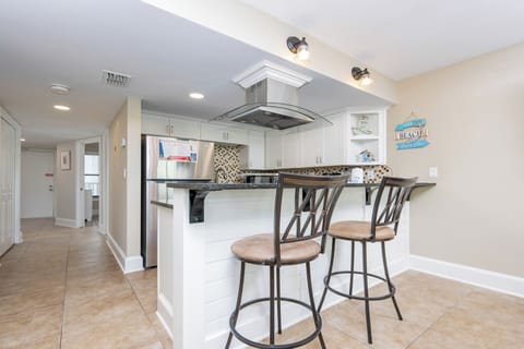 This kitchen features sleek stainless appliances, granite countertops, and a welcoming bar area perfect for casual dining