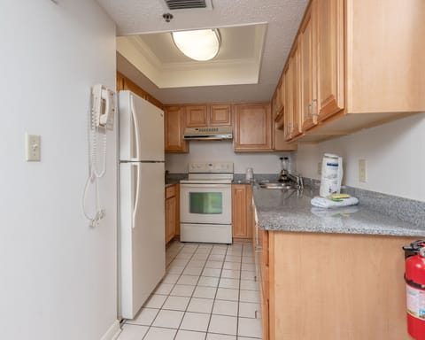 The kitchen features light wood cabinetry, granite countertops, and essential appliances, including a coffee maker