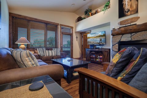 Unwind in this cozy mountain-inspired living room where you'll love the stone fireplace and rustic wood details.