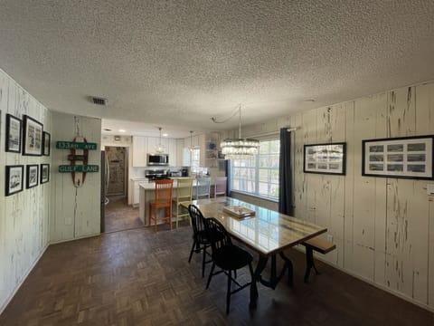 Dining area w\ original cypress walls, 100 year old table, breakfast bar & cool capiz shell light.