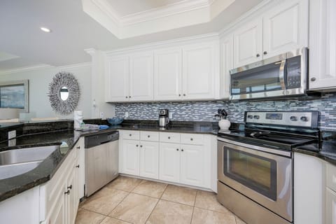 Bright and inviting kitchen featuring stainless appliances, granite countertops, and stylish mosaic backsplash