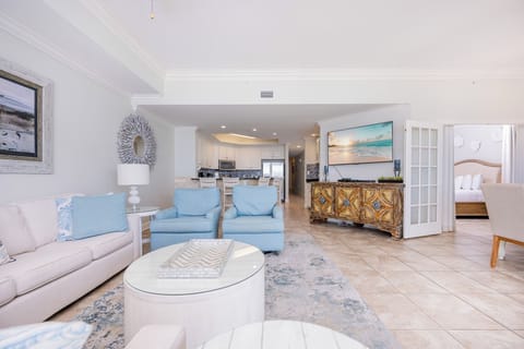 Inviting living area features cozy blue chairs, queen sofa-sleeper, a stylish coffee table, and a large TV for entertainment