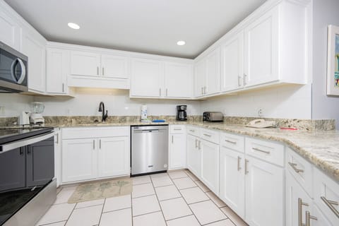 Prepare meals in the sleek kitchen featuring granite countertops, stainless appliances, and ample storage space