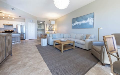 Relax in the spacious living area, featuring a comfortable sectional sofa, stylish decor, and a wooden coffee table