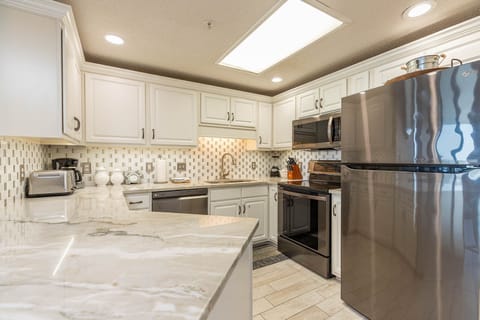 Cook and gather in this stylish kitchen featuring sleek appliances, elegant countertops, and ample storage space