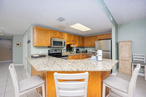 Gather around the granite breakfast bar, perfect for coffee and conversation in this inviting kitchen