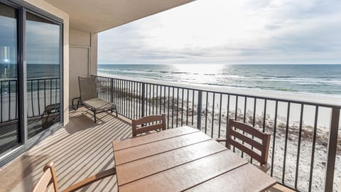 Savor the fresh air from your balcony, featuring a table and chairs with views of the tranquil waters and shoreline