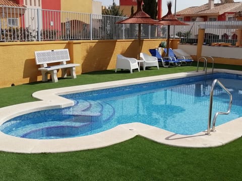 Pool with loungers & grassed area 