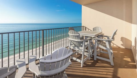 Relax in comfortable seating on the balcony while enjoying expansive views of the tranquil beach