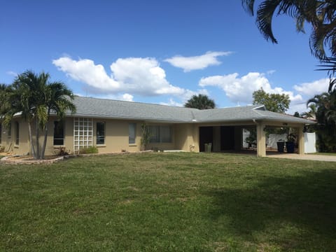 Front of the house, with a two car garage and a car port.