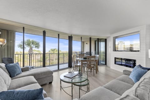 Spacious living room with panoramic windows, cozy fireplace and 65 inch Smart TV