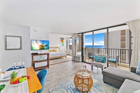 Cozy living room with great ocean view from the lanai, a window AC, cable TV, and a sliding door that separates the bedroom to the living room