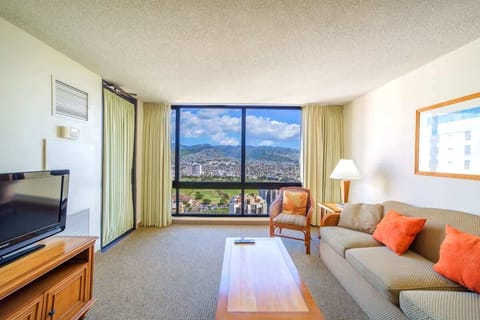Spacious living area with pull-out sleeper sofa, a coffee table, armchair, and nightstand. 