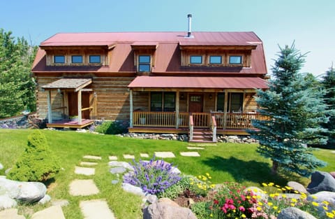 Flowers and green grass surround the home in late spring through the summer.